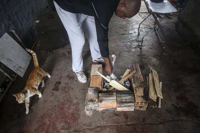 Para abastecer o fogo, Luis utiliza lenha, gravetos e pedaços de madeira que encontra na rua