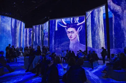 People attend the inauguration of the exhibition Frida, the immersive experience in Mexico City on July 6, 2021. - Images of the most famous paintings of iconic Mexican artist Frida Kahlo (1907-1954) are projected on enormous screens and curtains as traditional music plays, as part of a digital exposition that celebrates her life and work, which was premiered on the 114th anniversary of her birth. (Photo by CLAUDIO CRUZ / AFP) / RESTRICTED TO EDITORIAL USE - MANDATORY MENTION OF THE ARTIST UPON PUBLICATION - TO ILLUSTRATE THE EVENT AS SPECIFIED IN THE CAPTION<!-- NICAID(14828655) -->