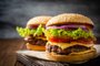Two homemade tasty burgers on wood tableDois hambúrgueres caseiros saborosos em mesa de madeira. Foco seletivo.Fonte: 282247995<!-- NICAID(14316627) -->