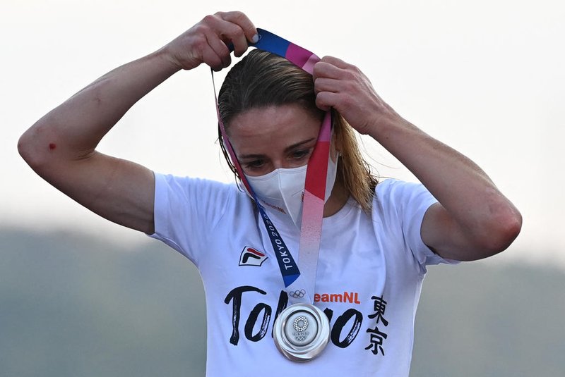 Silver medallist Netherlands Annemiek Van Vleuten puts on her medal on the podium during the medal ceremony for the womens cycling road race of the Tokyo 2020 Olympic Games, at the Fuji International Speedway in Oyama, Japan, on July 25, 2021. (Photo by Greg Baker / AFP)<!-- NICAID(14844290) -->