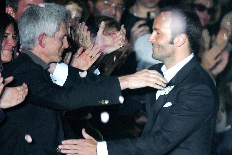 FASHION-ITALY-GUCCI-FORDUS designer Tom Ford (R) embraces his partner Richard Buckley, editor in chief of Vogue Hommes International as he acknowledges applause on the catwalk at the end of his last Gucci Autumn/Winter 2004-2005 women collection as part of the Milan fashion week 25 February 2004. (Photo by PATRICK HERTZOG / AFP)Editoria: ACELocal: MilanIndexador: PATRICK HERTZOGSecao: fashionFonte: AFP<!-- NICAID(14895004) -->