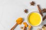 Turmeric drink, latte, tea, golden milk with cinnamon, ginger and anise in a mug on white background. top viewTurmeric drink, latte, tea, golden milk with cinnamon, ginger and anise in a mug on white background. top view with copy spaceFonte: 376789661<!-- NICAID(14913834) -->