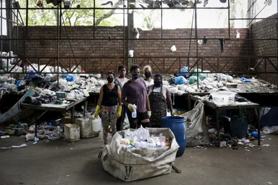 PORTO ALEGRE, RS, BRASIL, 13-10-2021: As recicladoras Silvia Lucidonio, 50, Rosani de Lima, 58, Eliana da Silva Almeida, 34, Sueli Lopes da Rosa, 50, e Cristiane Florencio, 42, durante o trabalho na Unidade de Triagem de Lixo Anjos da Ecologia, no bairro Floresta. O percentual de lixo reciclavel encaminhado para os galpoes de triagem esta em queda em Porto Alegre. Em unidades de triagem como a Anjos da Ecologia e Reciclando Pela Vida, a falta de material obriga as unidades a funcionar apenas alguns dias por semana e levou a um esquema de rodizio entre os recicladores. (Foto: Mateus Bruxel / Agencia RBS)Indexador: Mateus Bruxel<!-- NICAID(14913907) -->