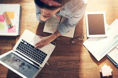Young female entrepreneur thinking and browsing laptop in officeFrom above entrepreneur woman browsing laptop and holding pencil while thinking at laptop in office.Indexador:                                Fonte: 158448081<!-- NICAID(14945284) -->