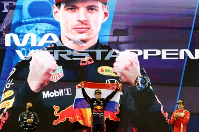 (fromL) Second-placed Mercedes British driver Lewis Hamilton, 2021 FIA Formula One World Champion Red Bulls Dutch driver Max Verstappen and third-placed Ferraris Spanish driver Carlos Sainz Jr celebrate on the podium of the Yas Marina Circuit after winning the Abu Dhabi Formula One Grand Prix on December 12, 2021. - Max Verstappen became the first Dutchman ever to win the Formula One world championship title when he won a dramatic season-ending Abu Dhabi Grand Prix. (Photo by Giuseppe CACACE / AFP)<!-- NICAID(14966000) -->