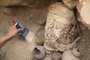 Um arqueólogo trabalha no sítio arqueológico de Cajamarquilla em 13 de fevereiro de 2022, onde foram encontradas seis múmias de crianças com idade estimada entre 800 e 1.200 anos, em Cajamarquilla, a 25 quilômetros de Lima. (Foto de GUADALUPE PARDO/AFP)<!-- NICAID(15016089) -->