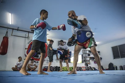 GRAVATAI, RS, BRASIL - 2022.03.16 - Um projeto tem ensinado Muay Thai a crianÃ§as e adolescentes com deficiencia em Gravatai. O Muay Thai Lutando pela Inclusao. A iniciativa e gratuita e fruto de uma parceria entre a Associaçao Camaleao Azul, de onde vem os alunos, e a escola de artes marciais World Thai. Na foto: Professor Patrick Silva (Foto: ANDRE AVILA/ Agencia RBS)Indexador: Andre Avila<!-- NICAID(15043140) -->