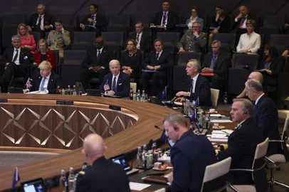 British Prime Minister Boris Johnson (L) and U.S. President Joe Biden (C) listen as NATO Secretary General Jens Stoltenberg (C/R) addresses a North Atlantic Council meeting  during an extrordinary summit at NATO Headquarters in Brussels on March 24, 2022. (Photo by EVELYN HOCKSTEIN / POOL / AFP)<!-- NICAID(15049636) -->