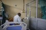 A patient infected with COVID-19 eats while sitting on his bed at ward number 20 of the Tembisa Hospital in Tembisa, on March 2, 2021. (Photo by Guillem Sartorio / AFP)Editoria: HTHLocal: TembisaIndexador: GUILLEM SARTORIOSecao: diseaseFonte: AFPFotógrafo: STR<!-- NICAID(15055065) -->