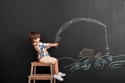 Cute little boy near black wall with drawn fishing rod - Pixel-Shot/Adobe StockFonte: 396248573<!-- NICAID(15206415) -->