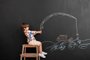 Cute little boy near black wall with drawn fishing rod - Pixel-Shot/Adobe StockFonte: 396248573<!-- NICAID(15206415) -->