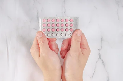 *A PEDIDO DE LUISA TESSUTO* Female hands holding birth control pills on a marble background - Foto: oasisamuel/stock.adobe.comFonte: 302111027<!-- NICAID(15227268) -->