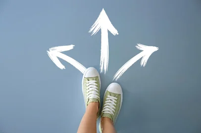 Woman standing on color background with arrows pointing in different directions. Concept of choice - Foto: Pixel-Shot/stock.adobe.comFonte: 232461236<!-- NICAID(15235915) -->