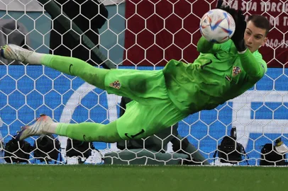 Croatias goalkeeper #01 Dominik Livakovic saves a shot by Brazils forward #21 Rodrygo during penalty shoot-out in the Qatar 2022 World Cup quarter-final football match between Croatia and Brazil at Education City Stadium in Al-Rayyan, west of Doha, on December 9, 2022. (Photo by JACK GUEZ / AFP)Editoria: SPOLocal: DohaIndexador: JACK GUEZSecao: soccerFonte: AFPFotógrafo: STF<!-- NICAID(15291013) -->