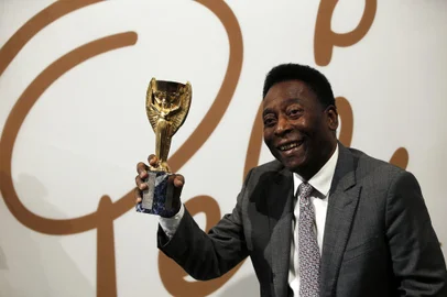 Former Brazilian footballer Pele holds a replica Jules Rimet trophy, a trophy awarded to the winner of the football World Cup, during an media interview at a preview for an auction of his memorabilia in London on June 1, 2016. - The three-time World Cup winner and FIFA Player of the Century is offering to auction his vast memorabilia collection including awards, personal property and iconic items from his entire career. The collection is being offered by Juliens Auction House on June 7, 8, 9 in London. (Photo by ADRIAN DENNIS / AFP)Editoria: HUMLocal: LondonIndexador: ADRIAN DENNISSecao: soccerFonte: AFPFotógrafo: STR<!-- NICAID(15304068) -->