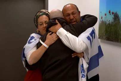 This handout picture released by the Israeli army shows released Israeli hostage Eitan Mor (C), one of the former captives in Gaza since the 2023 October 7 attacks by Palestinian militants, being embraced by his family after being handed over in a prisoner-hostage swap and a ceasefire deal between Israel and Hamas in Israel on October 13, 2025. (Photo by Israeli Army / AFP) / === RESTRICTED TO EDITORIAL USE - MANDATORY CREDIT "AFP PHOTO / HANDOUT / ISRAELI ARMY' - NO MARKETING NO ADVERTISING CAMPAIGNS - DISTRIBUTED AS A SERVICE TO CLIENTS ==<!-- NICAID(16144669) -->